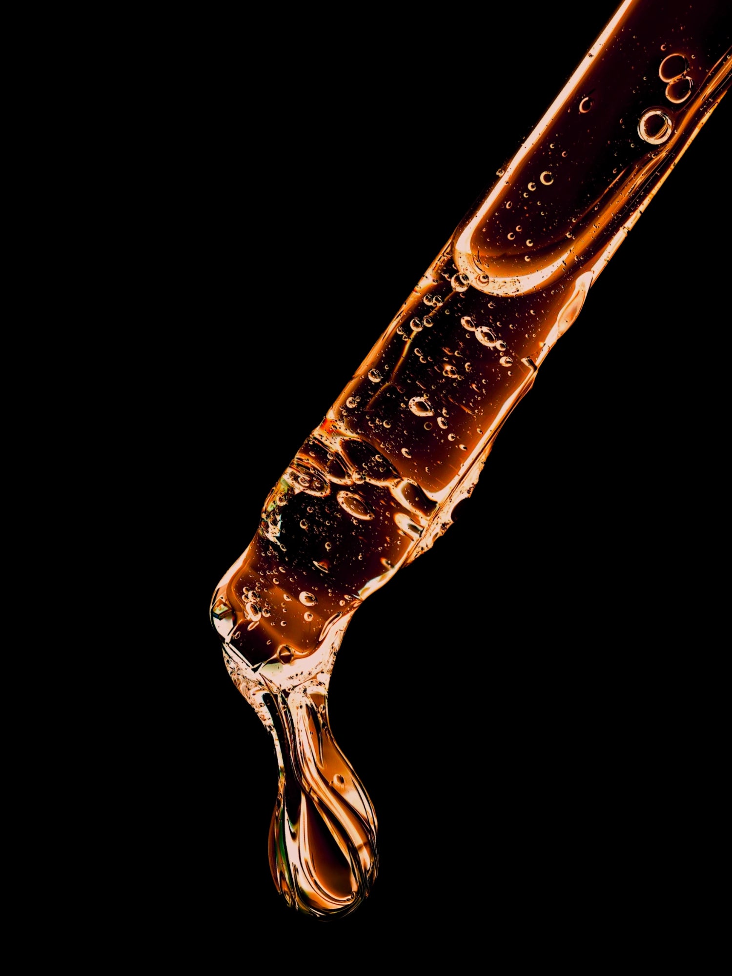 Close-up of a flowing liquid with bubbles on a black background
